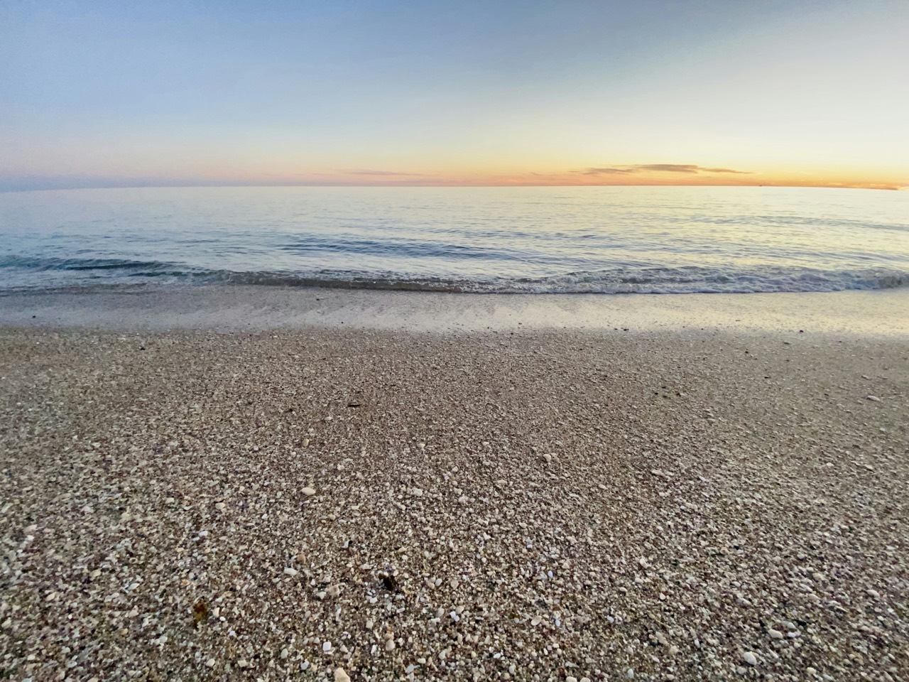 Calm water and shell-strewn sand at dusk, Rocky Point Beach