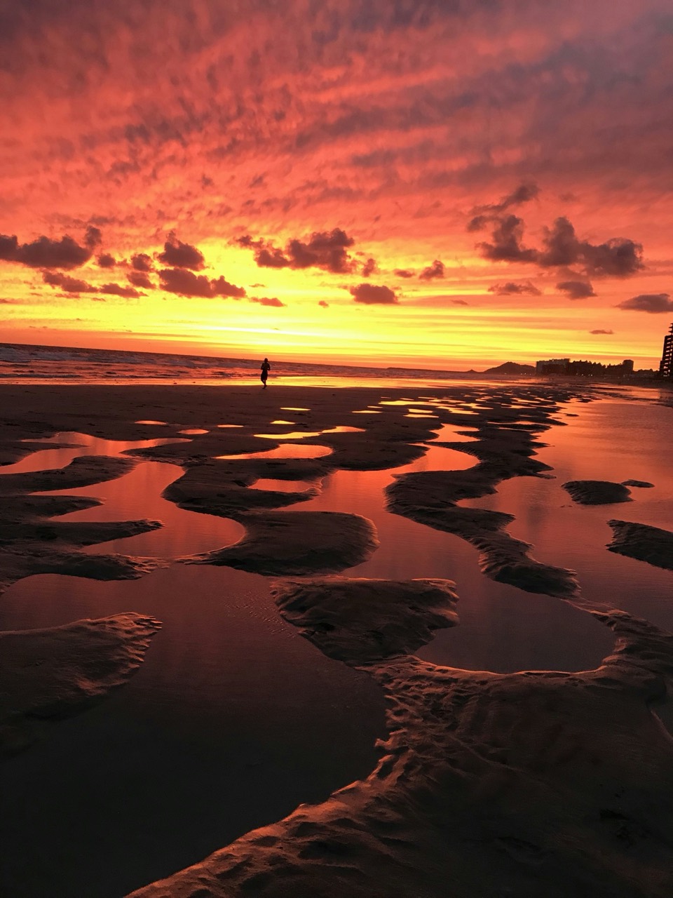 Tide pools reflecting a vivid sunset on a Puerto Peñasco beach